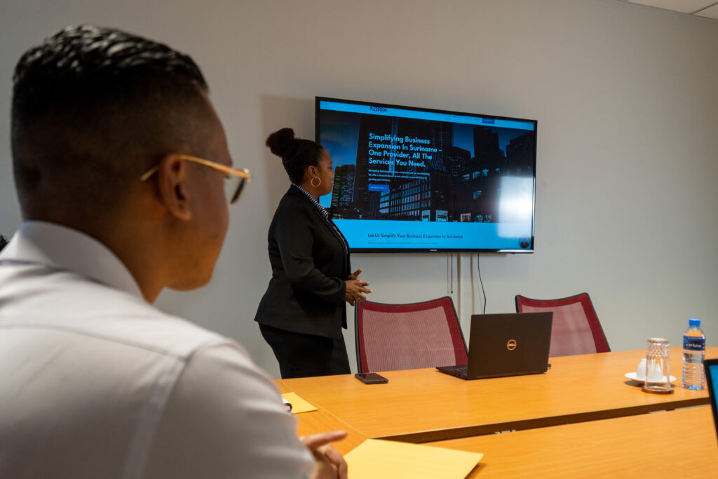 Businesswoman giving a presentation to a colleague in a conference room.