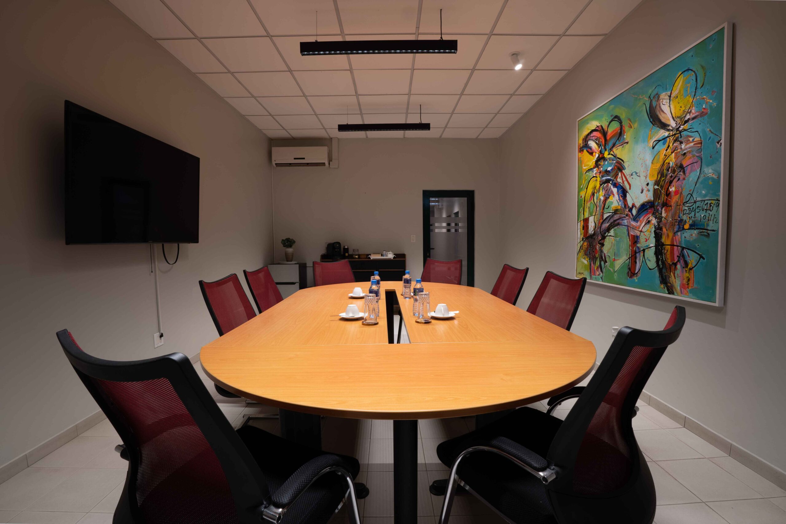 Virtual Office Suriname with conference room with a long table, chairs, and a large wall-mounted screen.